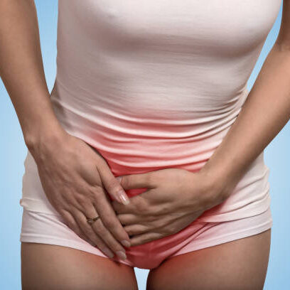 Close up cropped image of a woman with hands holding her crotch lower abdomen isolated on blue background